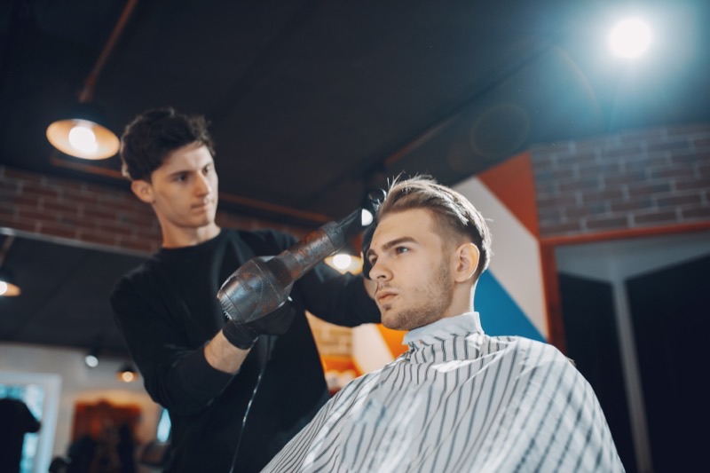 Barber student performing a professional haircut during barber training program